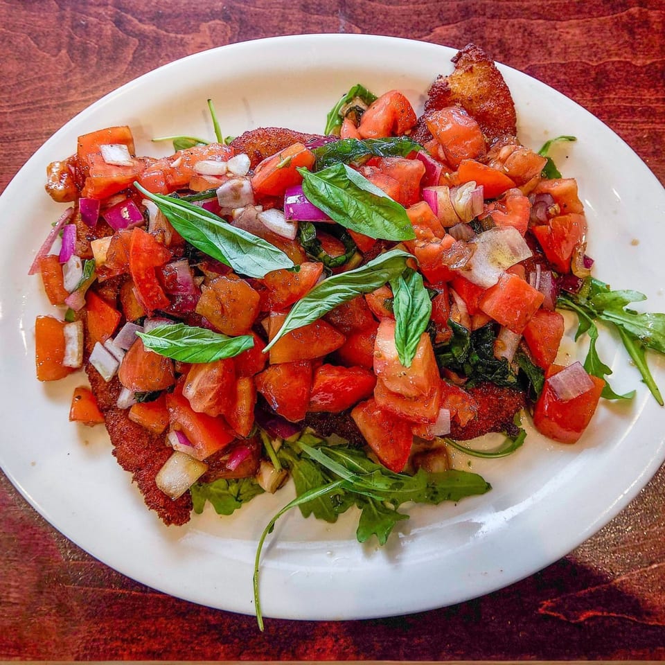 Nick's Italian chicken cutlet topped with diced tomatoes, red onions, and fresh basil.